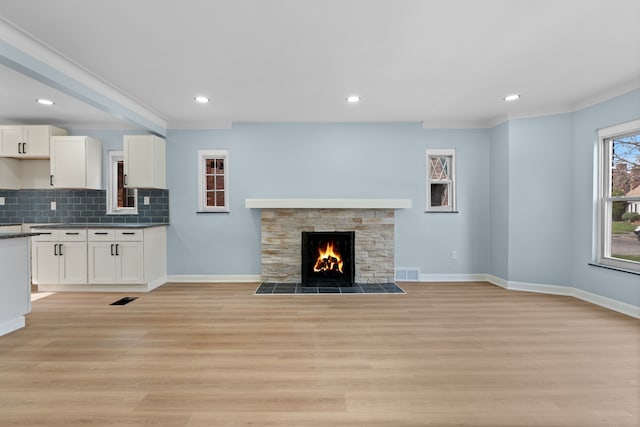 19319 Pennington Dr, Detroit, MI 48221 - unfurnished living room with recessed lighting, a stone fireplace, visible vents, light wood-style floors, and baseboards