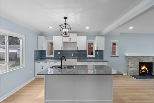 19319 Pennington Dr, Detroit, MI 48221 - kitchen with white cabinets, a sink, and a center island with sink
