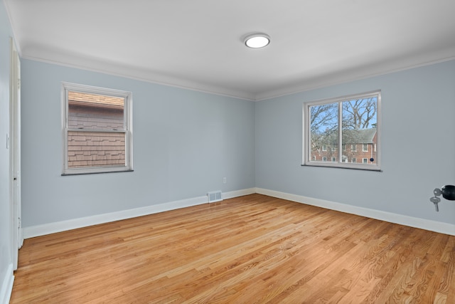 19319 Pennington Dr, Detroit, MI 48221 - empty room featuring light wood-style floors, visible vents, baseboards, and ornamental molding