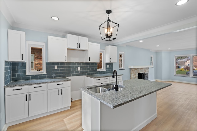 19319 Pennington Dr, Detroit, MI 48221 - kitchen with white cabinets, light wood finished floors, light stone counters, and a sink