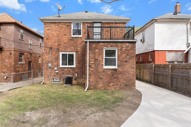 19319 Pennington Dr, Detroit, MI 48221 - rear view of house with a fenced backyard, brick siding, a yard, and a balcony