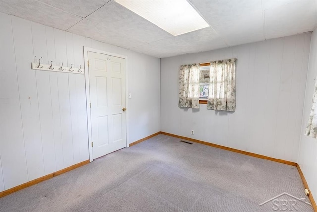 interior space featuring baseboards, visible vents, and carpet