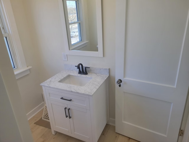 bathroom featuring vanity, baseboards, and wood finished floors