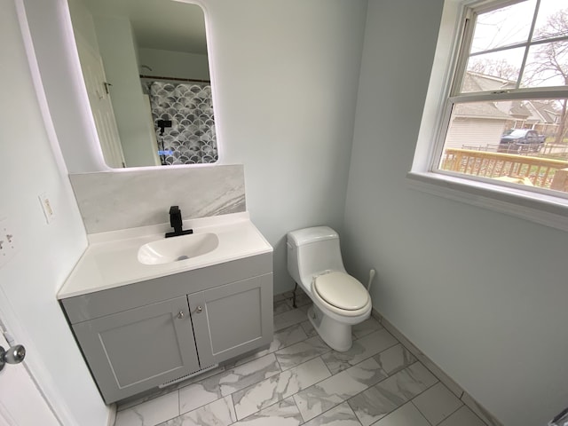full bath featuring marble finish floor, toilet, vanity, baseboards, and a shower with shower curtain