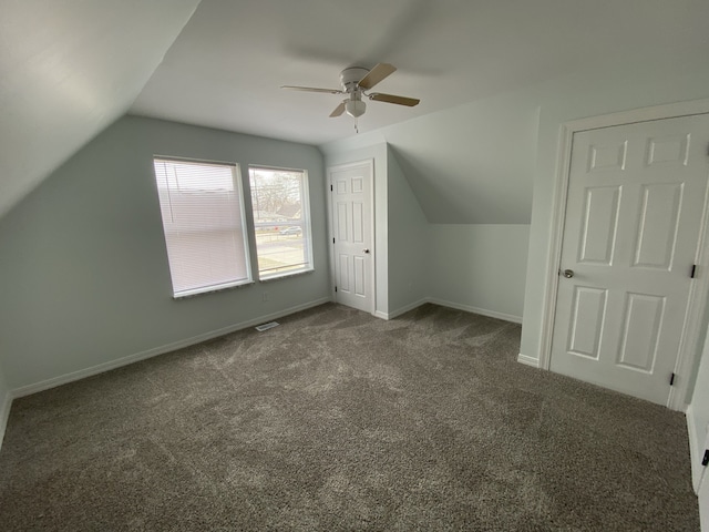 additional living space featuring vaulted ceiling, visible vents, baseboards, a ceiling fan, and carpet floors