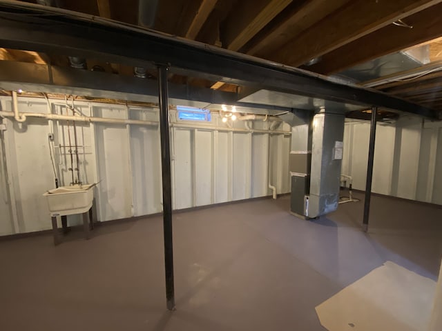 unfinished below grade area with heating unit and a sink