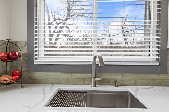 details featuring light stone counters and a sink