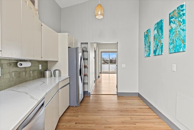 kitchen with dishwasher, light wood-style floors, decorative backsplash, stainless steel refrigerator with ice dispenser, and white cabinetry