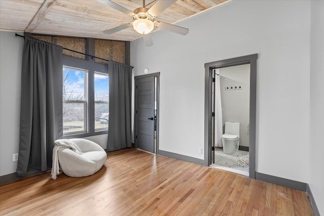 bedroom featuring connected bathroom, light wood-style floors, ceiling fan, wooden ceiling, and baseboards