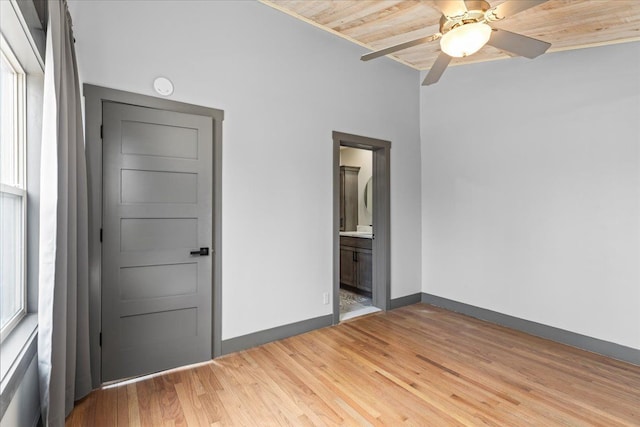 unfurnished bedroom with a ceiling fan, crown molding, ensuite bathroom, light wood-type flooring, and baseboards