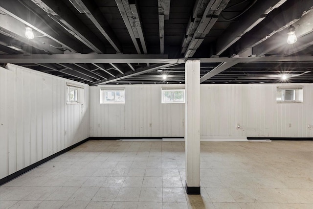 below grade area featuring wooden walls and light floors