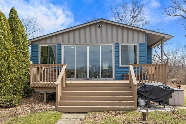 rear view of house with a wooden deck and stairway