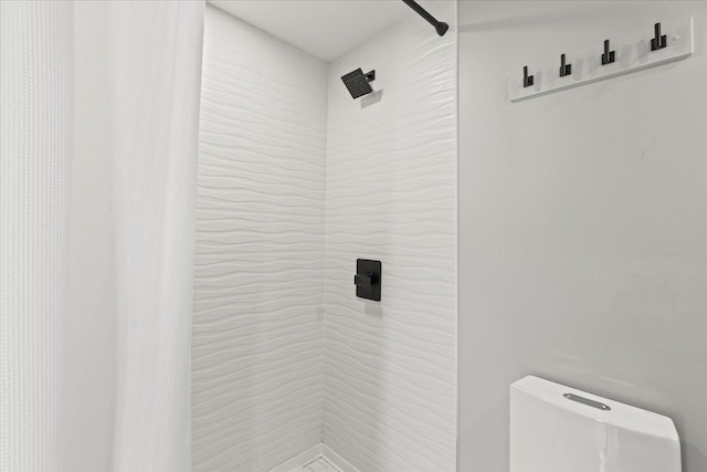 full bathroom featuring toilet and tiled shower
