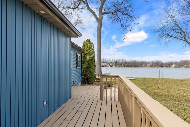 wooden deck with a lawn and a water view