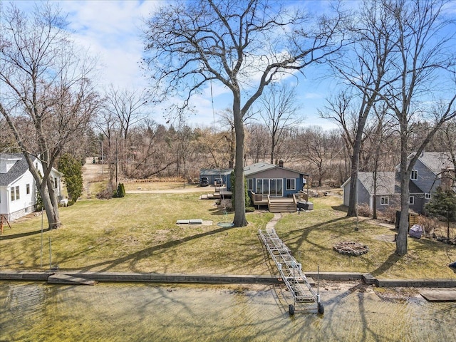 view of yard featuring a wooden deck, an outbuilding, and an outdoor fire pit