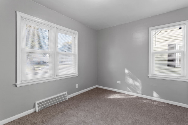 unfurnished room with baseboards, visible vents, and carpet