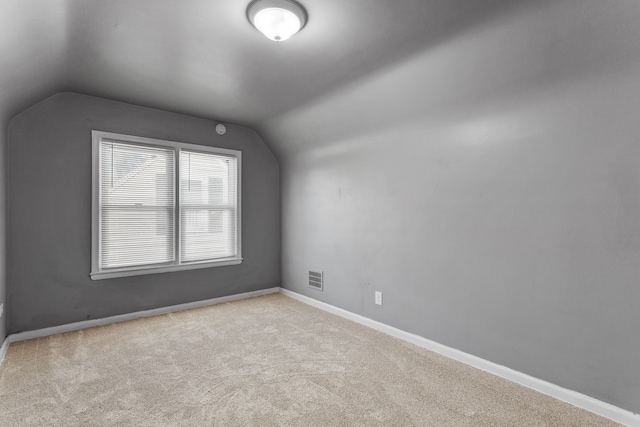additional living space featuring vaulted ceiling, carpet floors, visible vents, and baseboards