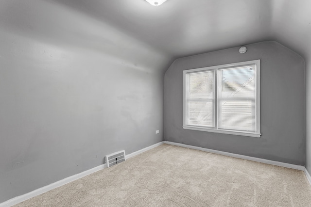 additional living space featuring vaulted ceiling, visible vents, carpet flooring, and baseboards