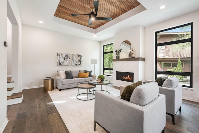 2359 Elinor Ln SE, East Grand Rapids, MI 49506 - living room with wooden ceiling, a warm lit fireplace, a tray ceiling, and baseboards