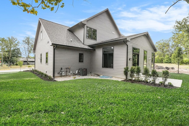2359 Elinor Ln SE, East Grand Rapids, MI 49506 - rear view of house featuring a lawn, a shingled roof, and central AC unit
