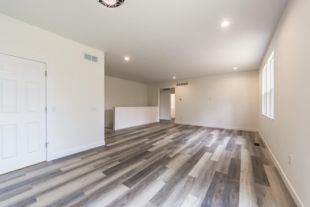unfurnished living room featuring wood finished floors, recessed lighting, and baseboards