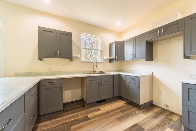 kitchen with a sink, dark wood-type flooring, gray cabinetry, and recessed lighting