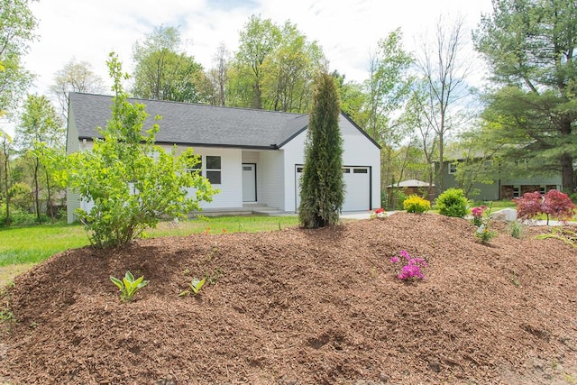 ranch-style home featuring a garage and a shingled roof
