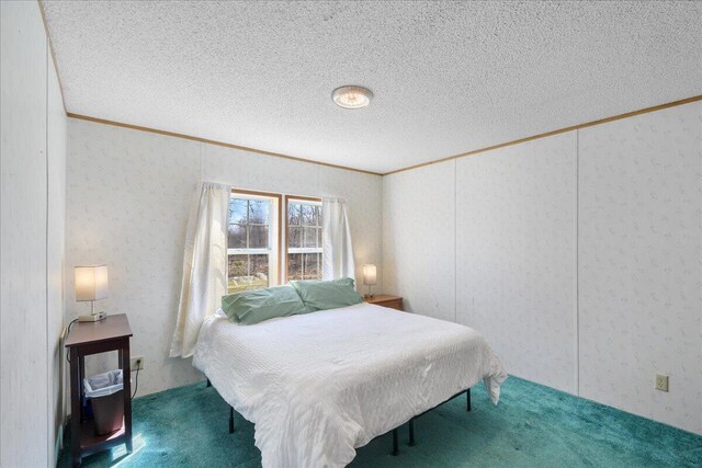 bedroom featuring carpet, a textured ceiling, and ornamental molding
