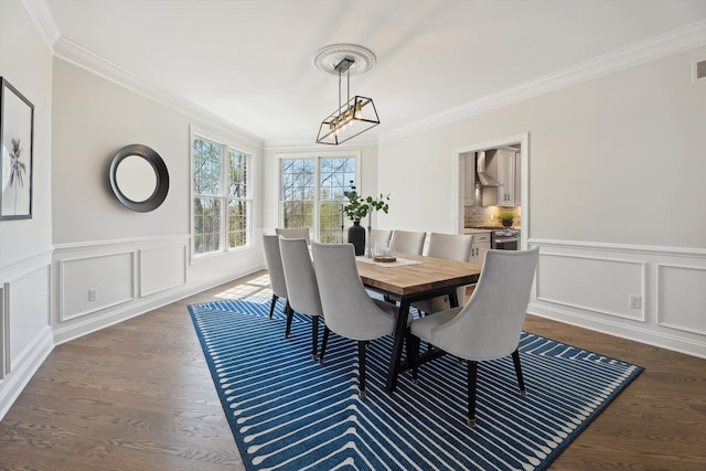 dining room featuring visible vents, wainscoting, ornamental molding, a decorative wall, and dark wood-type flooring