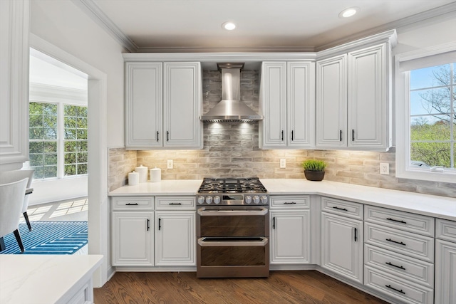 kitchen with decorative backsplash, dark wood-style flooring, double oven range, white cabinetry, and wall chimney exhaust hood