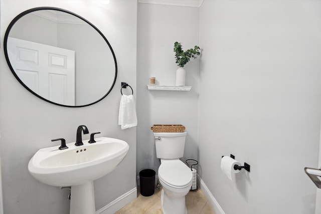 bathroom with toilet, baseboards, ornamental molding, and tile patterned flooring