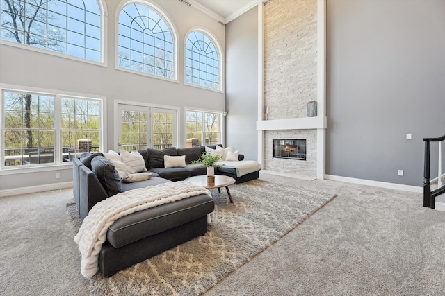 carpeted living room with baseboards, crown molding, and a healthy amount of sunlight