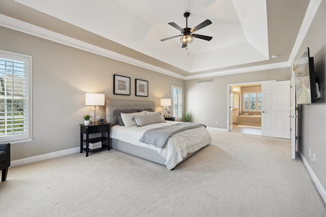 bedroom featuring baseboards, visible vents, a tray ceiling, and light colored carpet