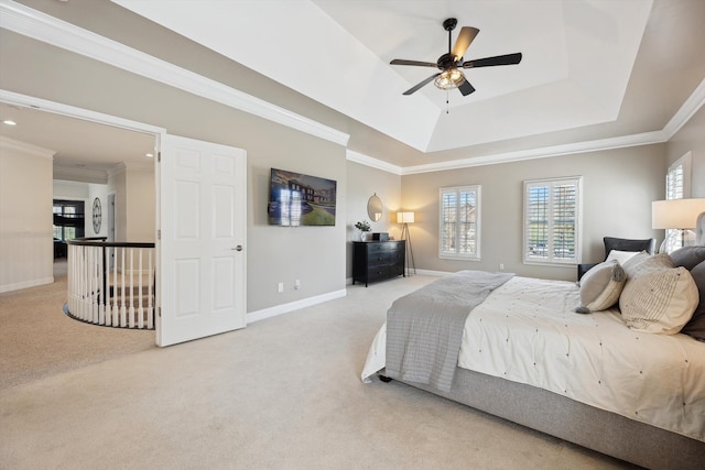 bedroom featuring crown molding, a tray ceiling, multiple windows, and carpet