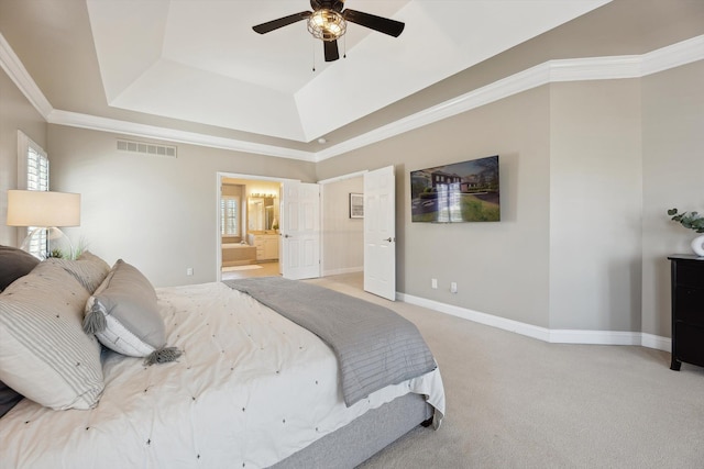 bedroom with visible vents, light carpet, ensuite bathroom, baseboards, and a raised ceiling