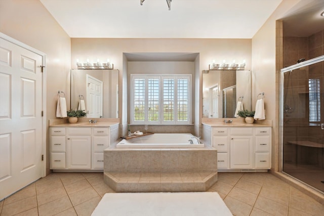 full bathroom featuring a sink, tile patterned flooring, a shower stall, and a garden tub