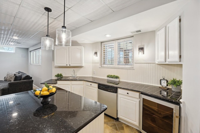 kitchen with hanging light fixtures, wine cooler, white cabinetry, and dishwasher