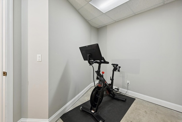workout room with baseboards and a paneled ceiling