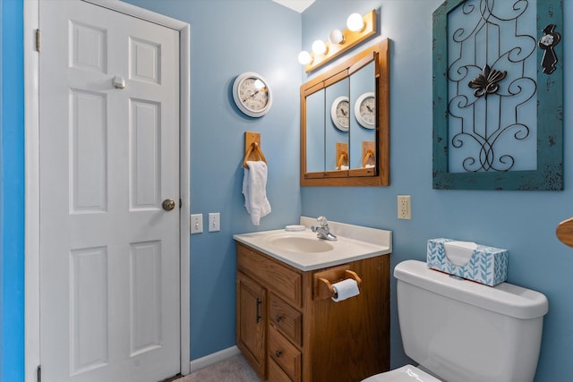 bathroom with baseboards, vanity, and toilet
