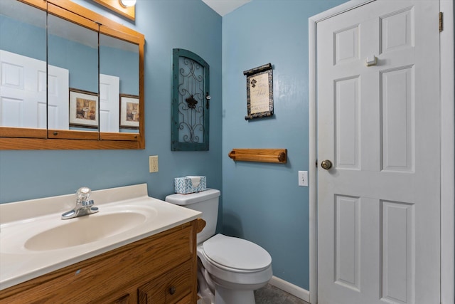 half bathroom featuring baseboards, vanity, and toilet
