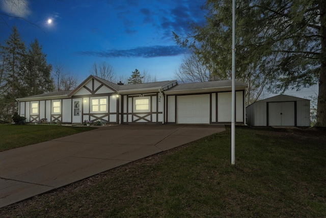 view of front facade featuring a storage shed, an outbuilding, concrete driveway, a garage, and a front yard