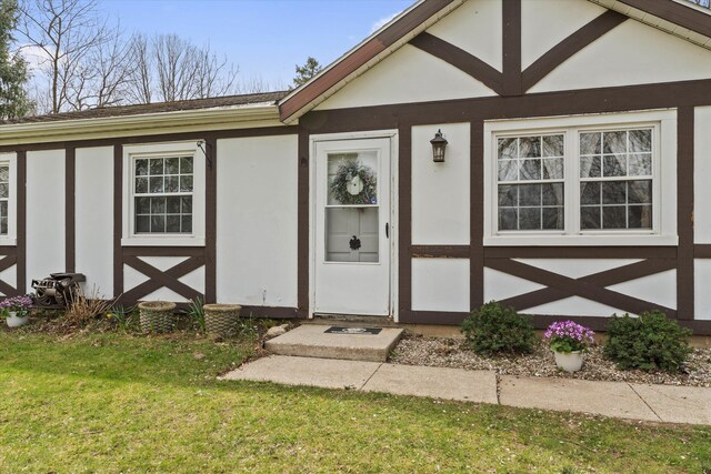 property entrance with a yard and stucco siding