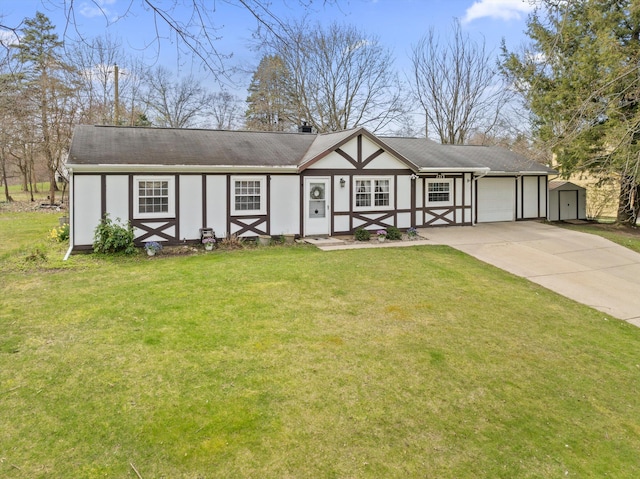 view of front of property with a storage unit, an outbuilding, concrete driveway, a garage, and a front yard