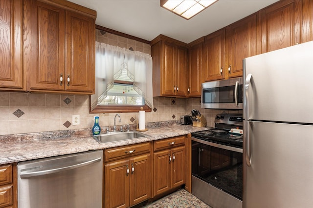 kitchen with brown cabinets, appliances with stainless steel finishes, and a sink