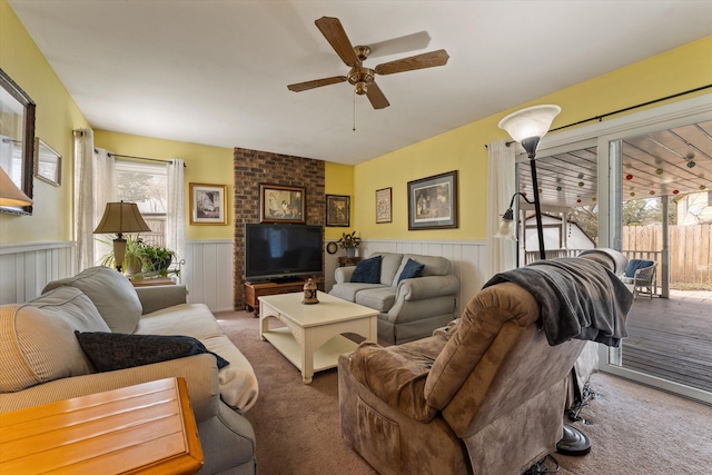living area with wainscoting, a ceiling fan, and carpet floors
