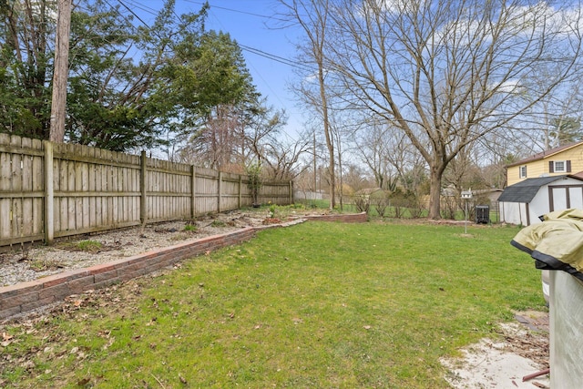 view of yard with an outbuilding, a shed, a fenced backyard, and central AC