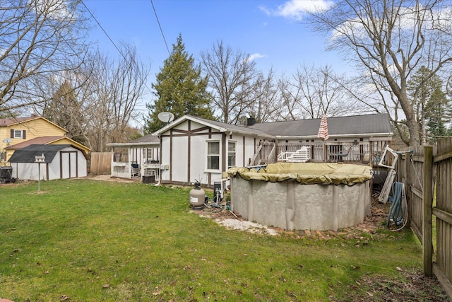 rear view of property with a lawn, a fenced backyard, an outbuilding, and a shed