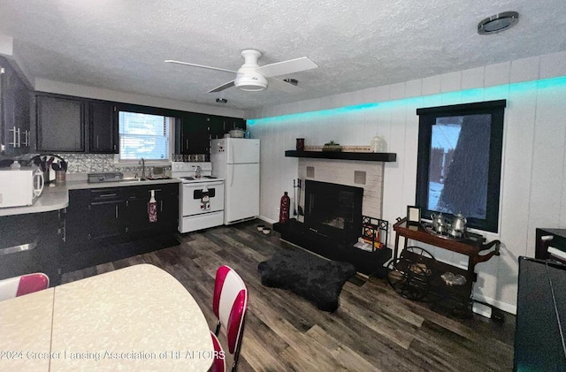 17669 Lake Dr, Barryton, MI 49305 - living area featuring ceiling fan, dark wood finished floors, a fireplace with raised hearth, and a textured ceiling