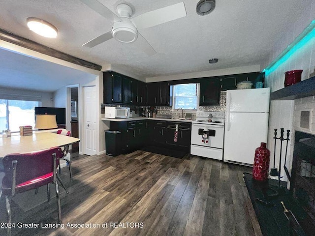 17669 Lake Dr, Barryton, MI 49305 - kitchen featuring white appliances, dark cabinetry, plenty of natural light, dark wood-style flooring, and a textured ceiling