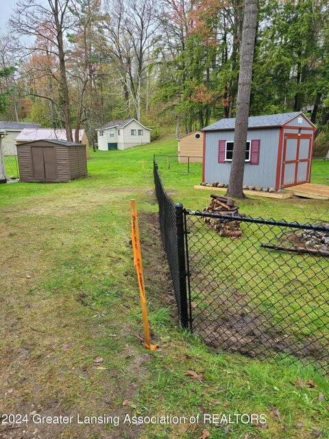 17669 Lake Dr, Barryton, MI 49305 - view of yard with a shed, an outdoor structure, and view of wooded area